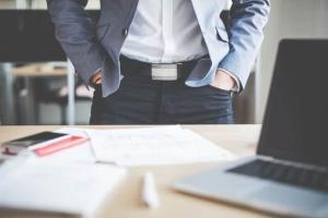 Image of a man standing at a desk.