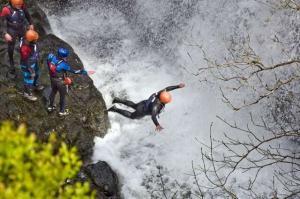 Photo of man jumping into a waterfall.