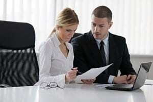 Two colleagues reviewing a document.