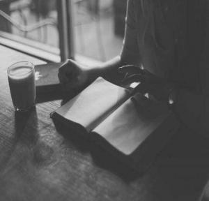 Person reading a book with a cup of coffee